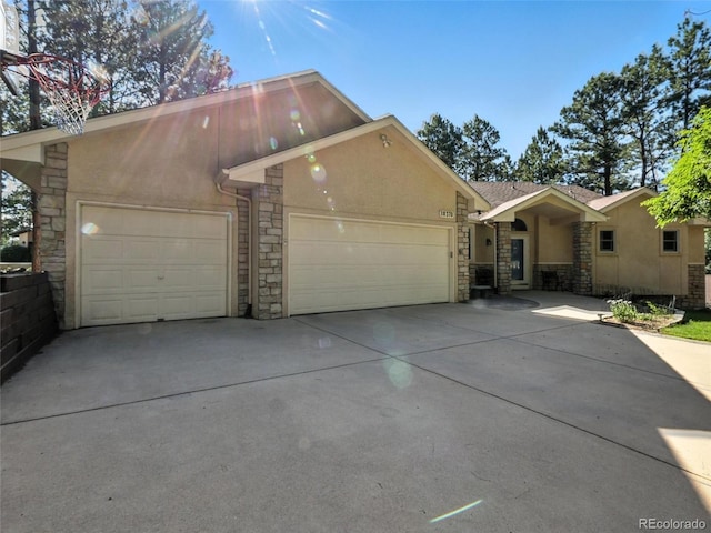 view of front of house with stone siding, stucco siding, concrete driveway, and an attached garage
