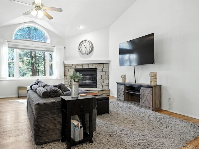 living room with vaulted ceiling, wood finished floors, a ceiling fan, and a fireplace