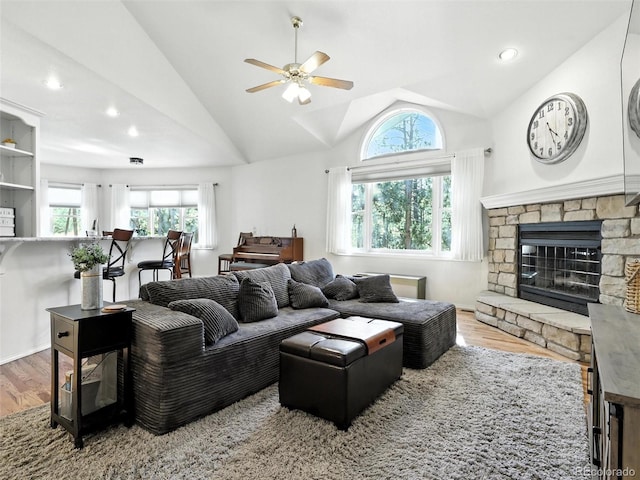 living area with wood finished floors, ceiling fan, lofted ceiling, a fireplace, and recessed lighting