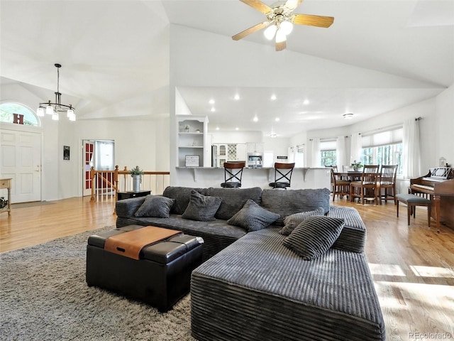 living area featuring light wood-type flooring, high vaulted ceiling, a chandelier, ceiling fan, and recessed lighting