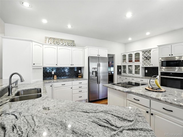 kitchen featuring stainless steel appliances, tasteful backsplash, white cabinets, and recessed lighting