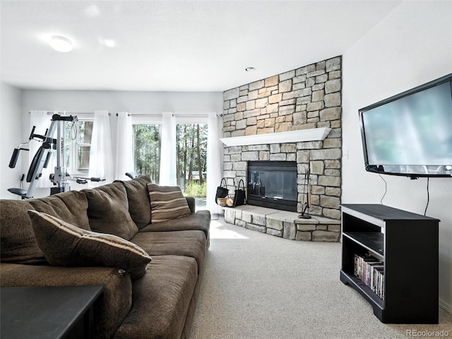 carpeted living area featuring a stone fireplace