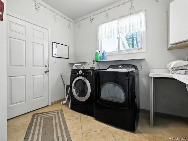 laundry area with cabinet space, washer and clothes dryer, and light tile patterned floors