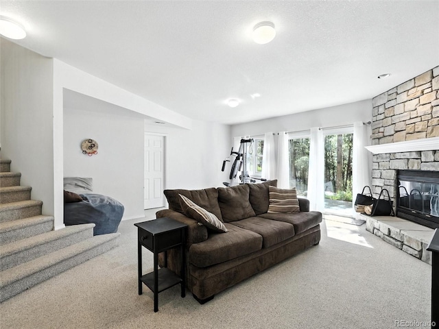 carpeted living area featuring stairs and a fireplace