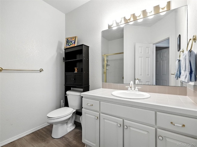full bathroom featuring wood finished floors, vanity, and a shower with shower door