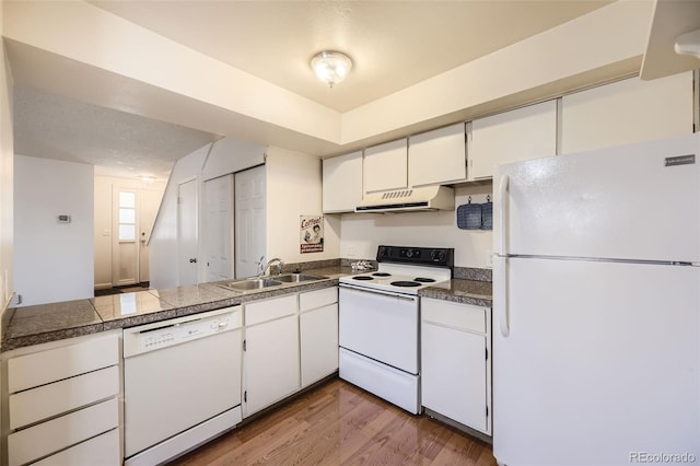 kitchen featuring white appliances, sink, a textured ceiling, white cabinetry, and light hardwood / wood-style floors