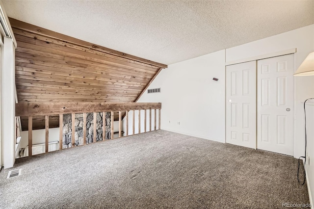 additional living space featuring lofted ceiling, a textured ceiling, and carpet flooring