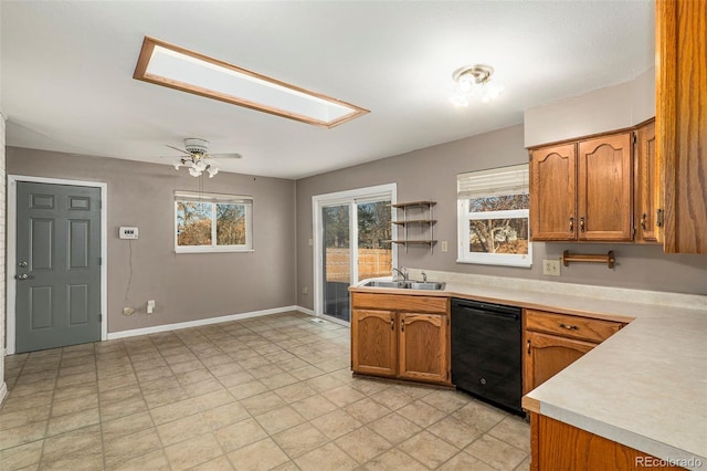 kitchen featuring sink, a skylight, black dishwasher, and ceiling fan