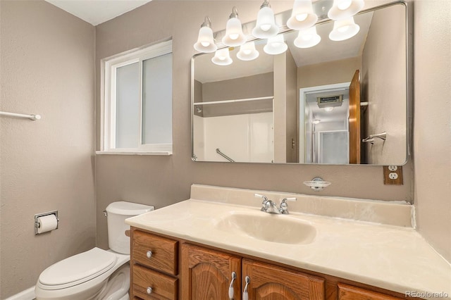 bathroom featuring vanity, toilet, and walk in shower