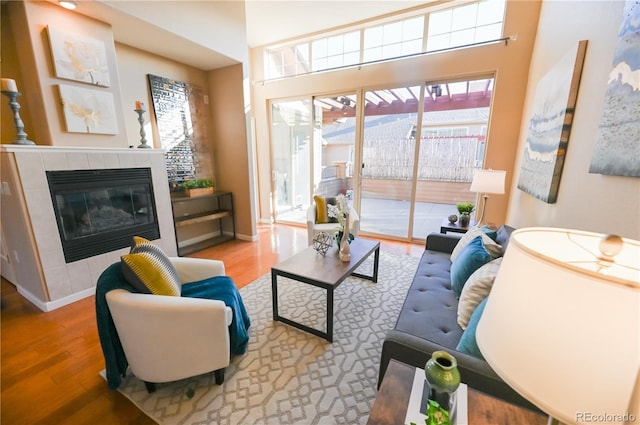 living room featuring a tile fireplace and hardwood / wood-style floors