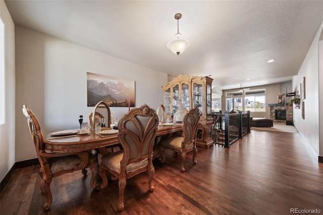 dining room featuring a textured ceiling, dark wood-type flooring, and ceiling fan