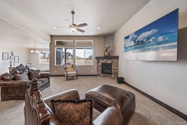 carpeted living room featuring a healthy amount of sunlight, ceiling fan with notable chandelier, a stone fireplace, and a textured ceiling