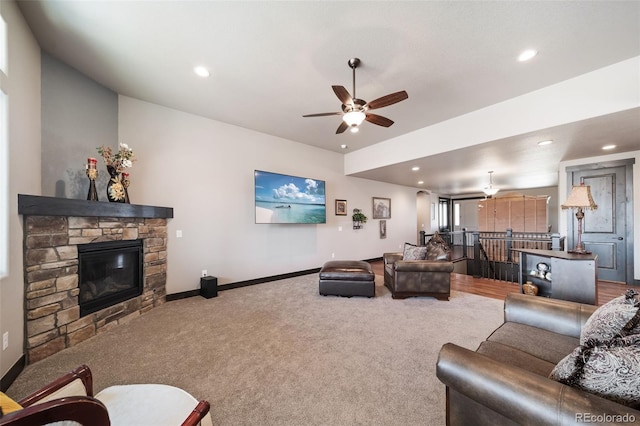 carpeted living room with ceiling fan and a fireplace