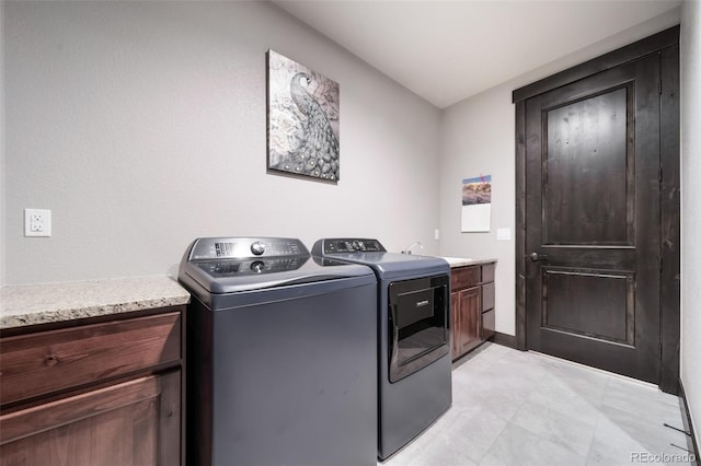 washroom featuring cabinets, washing machine and dryer, and sink