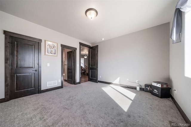 unfurnished bedroom with dark colored carpet