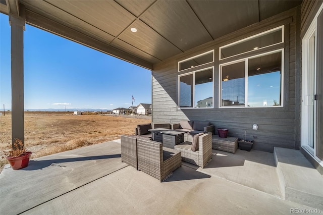 view of patio with an outdoor living space with a fire pit