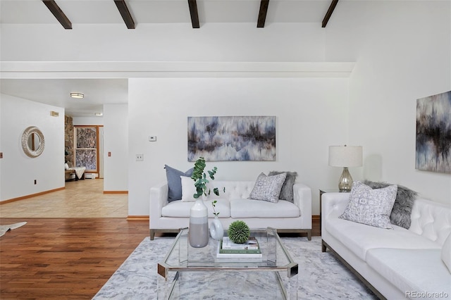 living area with beamed ceiling, baseboards, and wood finished floors