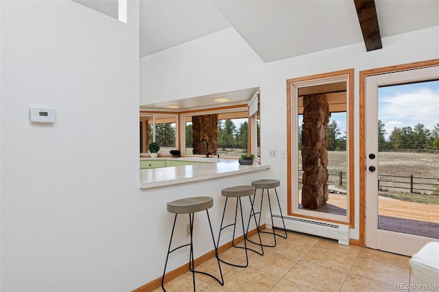 dining room with light tile patterned floors, beamed ceiling, baseboards, and a baseboard radiator