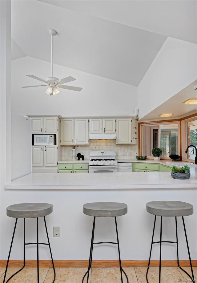 kitchen featuring ceiling fan, white appliances, a peninsula, and a sink