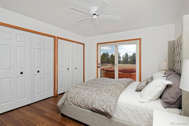 bedroom featuring access to exterior, dark wood-style floors, two closets, and a ceiling fan