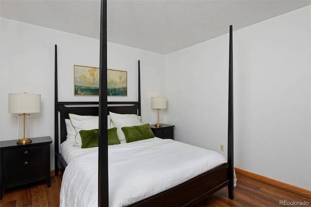 bedroom featuring wood finished floors and baseboards