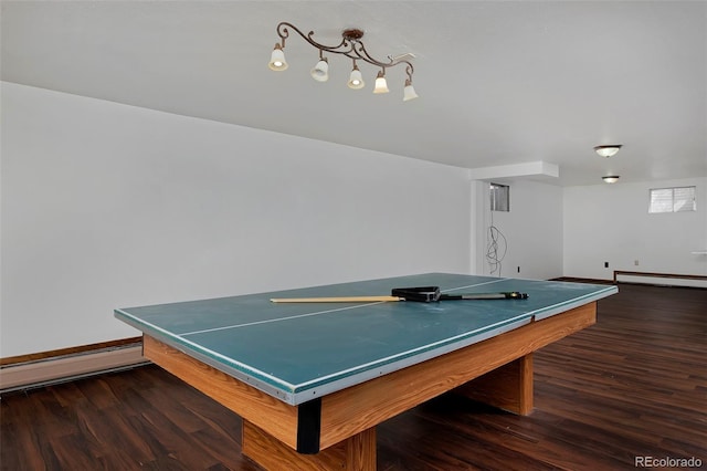 playroom with a baseboard heating unit, wood finished floors, and baseboards