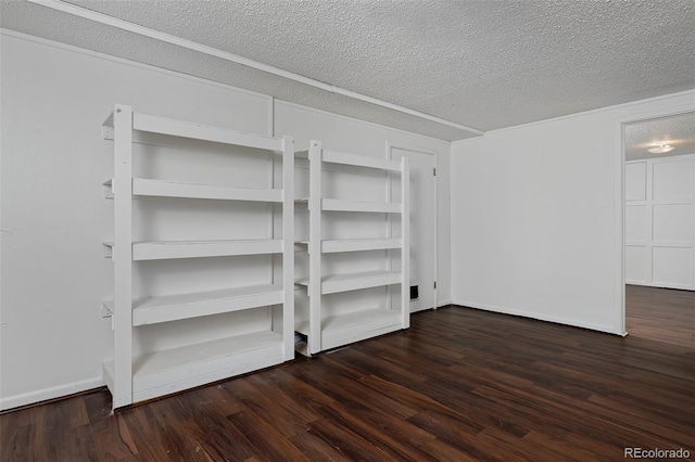 interior space with a textured ceiling, dark wood-type flooring, and baseboards