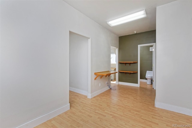 unfurnished room with baseboards and light wood finished floors