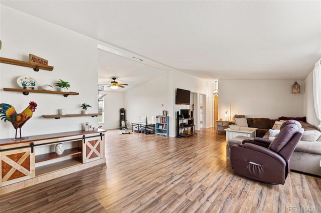 living room with hardwood / wood-style flooring, vaulted ceiling, and ceiling fan