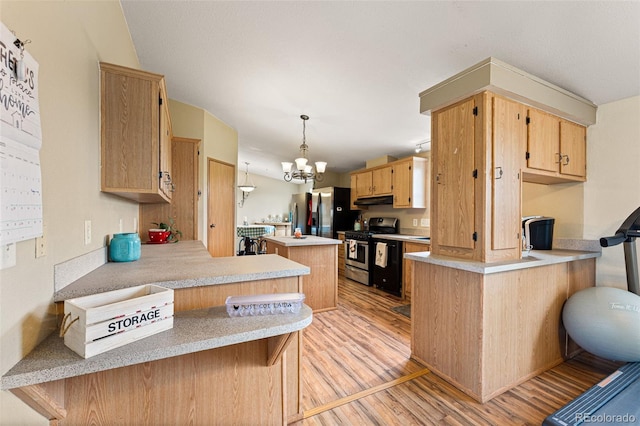 kitchen featuring appliances with stainless steel finishes, pendant lighting, a kitchen bar, light hardwood / wood-style floors, and kitchen peninsula