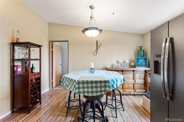 dining space with hardwood / wood-style flooring and lofted ceiling