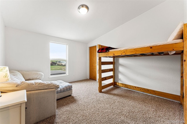 carpeted bedroom featuring lofted ceiling