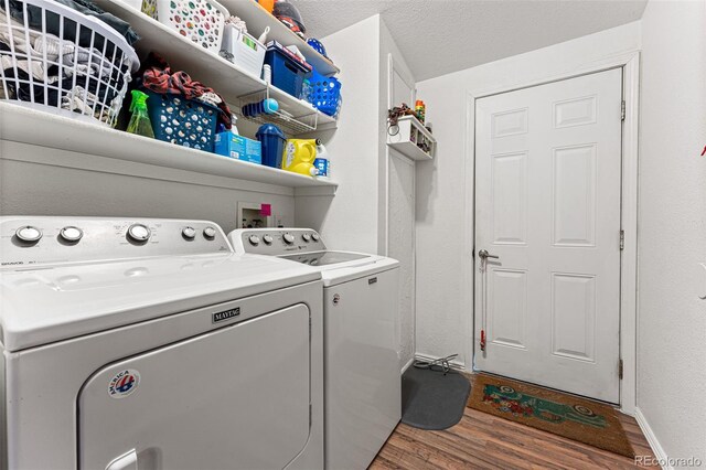 laundry area with dark wood-type flooring, washer and dryer, and a textured ceiling