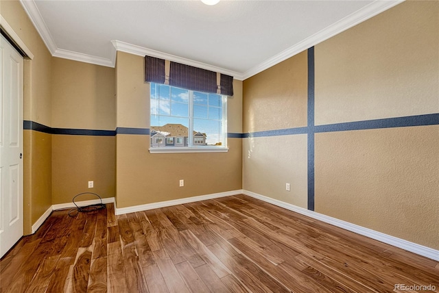 spare room featuring crown molding and wood-type flooring