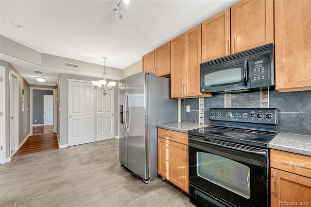 kitchen with tasteful backsplash, black appliances, decorative light fixtures, light hardwood / wood-style flooring, and a chandelier