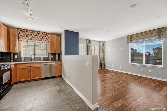 kitchen with sink, stainless steel dishwasher, black / electric stove, wood-type flooring, and decorative backsplash