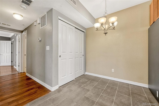 interior space featuring hardwood / wood-style flooring and an inviting chandelier