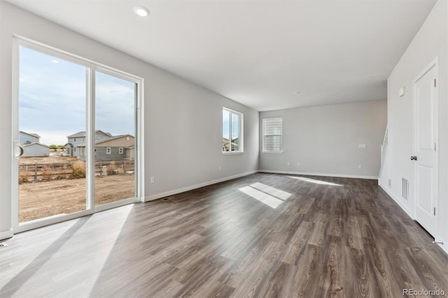 unfurnished room with dark hardwood / wood-style flooring and a healthy amount of sunlight