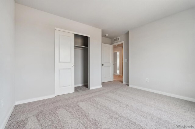 unfurnished bedroom with carpet flooring and a closet