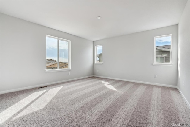 unfurnished room featuring light carpet