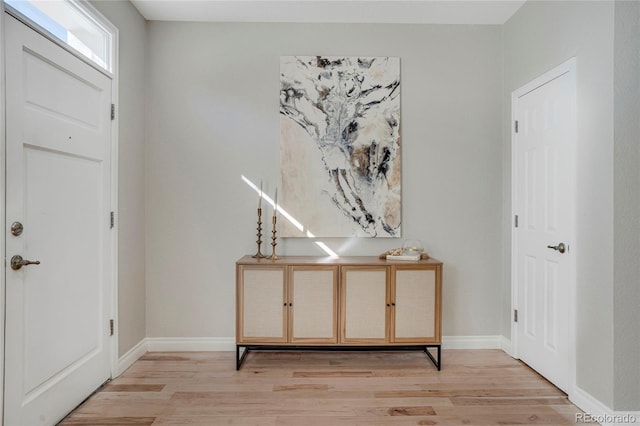 entryway with light wood-style flooring and baseboards