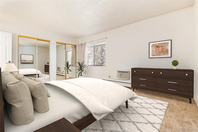 carpeted bedroom with a textured ceiling, baseboard heating, a wall mounted AC, and two closets