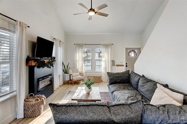 living room with lofted ceiling, ceiling fan, and light hardwood / wood-style flooring