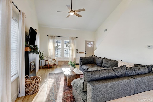 living room with high vaulted ceiling, ceiling fan, and light hardwood / wood-style flooring