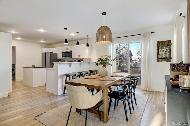 dining space featuring washer / dryer and light hardwood / wood-style floors