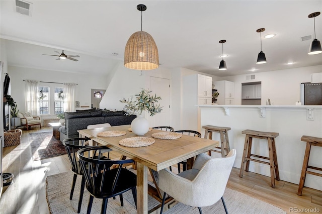 dining room with ceiling fan and light hardwood / wood-style floors