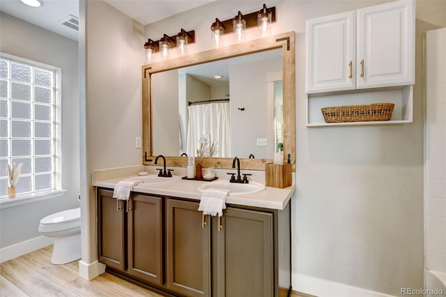 bathroom with a shower with curtain, hardwood / wood-style floors, vanity, and toilet