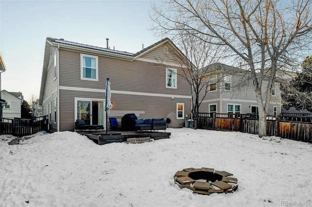 snow covered rear of property with an outdoor fire pit and central air condition unit