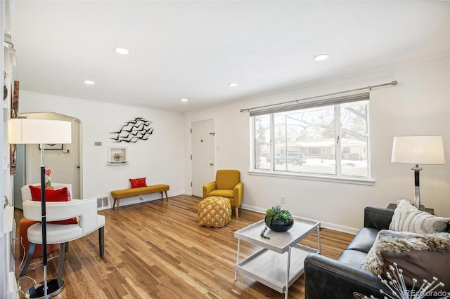 living room with hardwood / wood-style flooring and ornamental molding