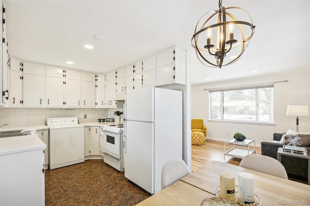 kitchen featuring washer / clothes dryer, pendant lighting, white cabinets, and white appliances